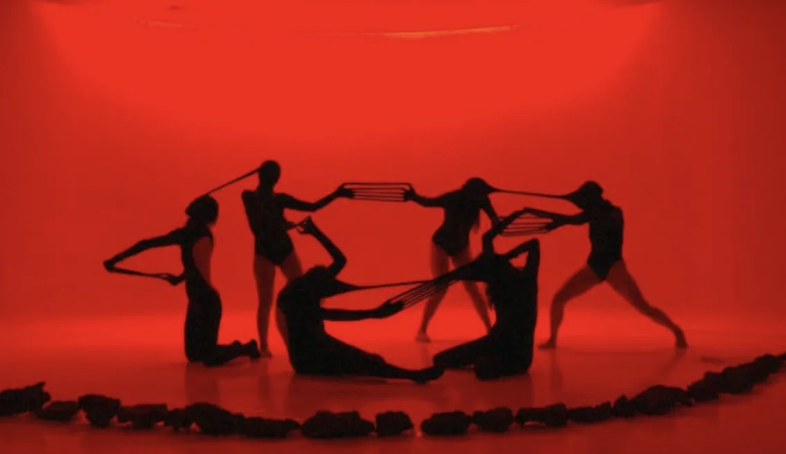 Dancers performing Deslenguadas in red light