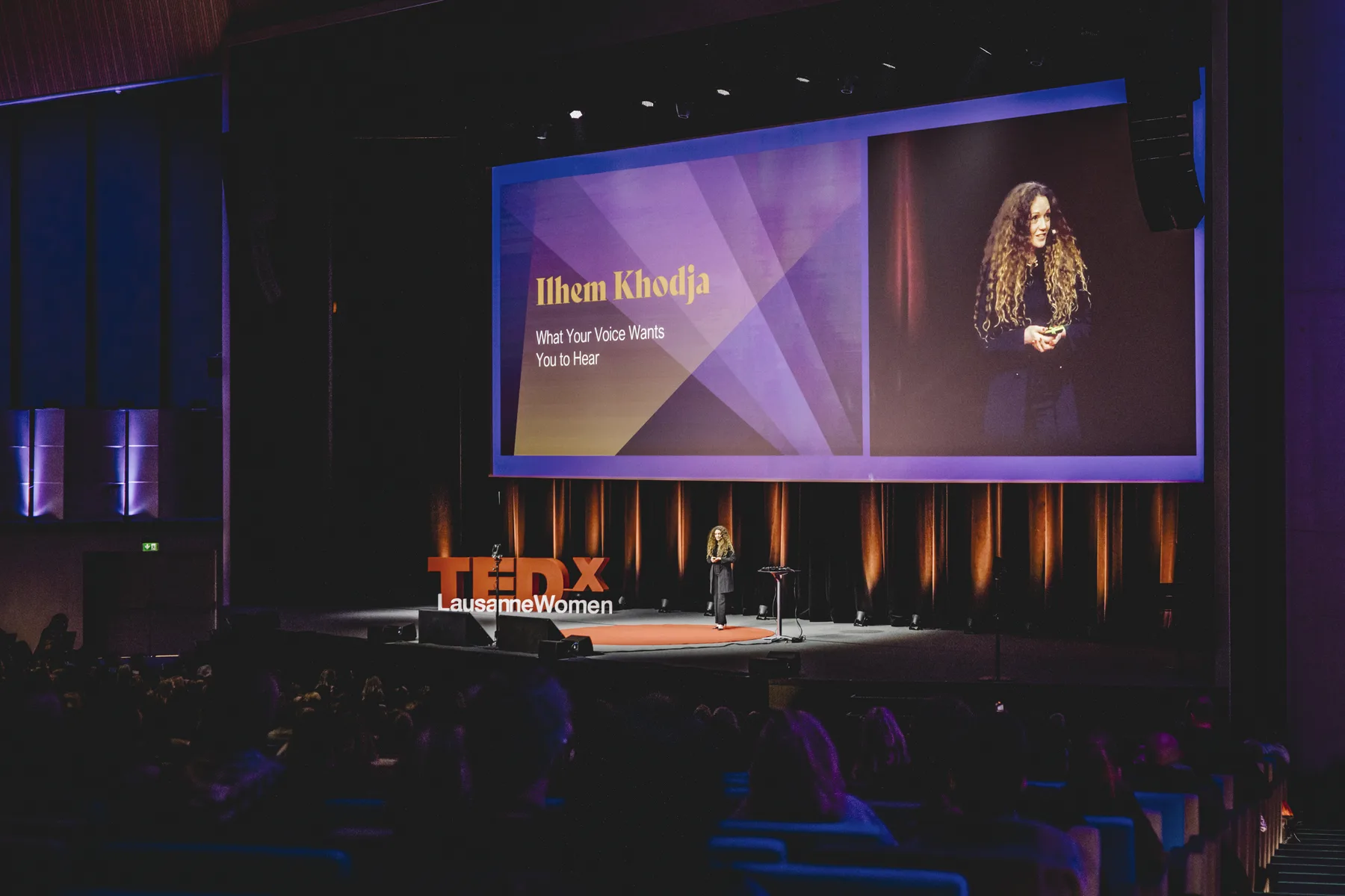 Ilhem speaking on stage at TEDxWomen Lausanne